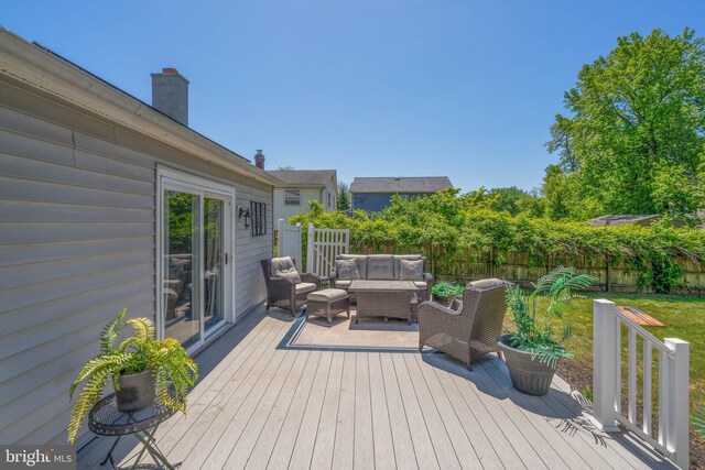 deck with outdoor lounge area and a fenced backyard