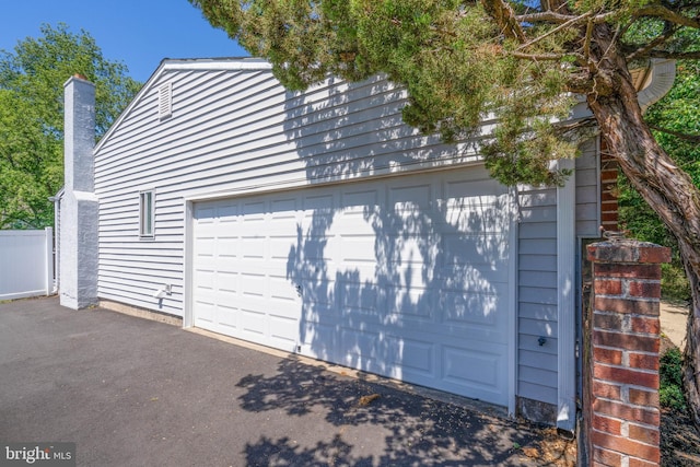 garage featuring asphalt driveway