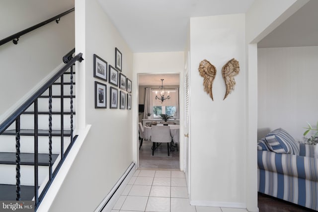 corridor with a chandelier, stairway, a baseboard heating unit, and tile patterned flooring