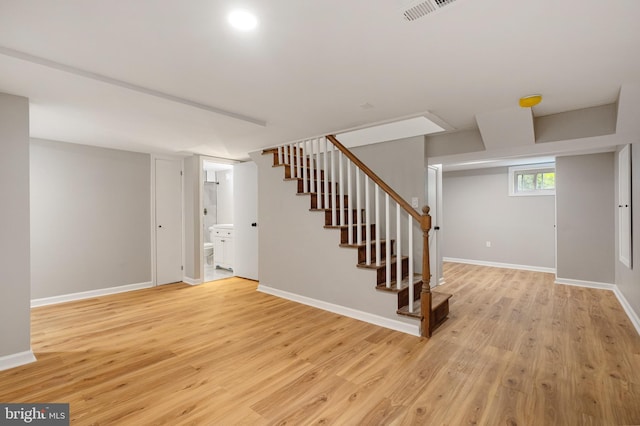 5311 Herring Run Dr, Baltimore, MD 21214 - below grade area with stairway, light wood-style flooring, and baseboards