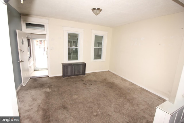 carpeted empty room with baseboards