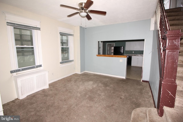 unfurnished living room with carpet, ceiling fan, stairway, and baseboards