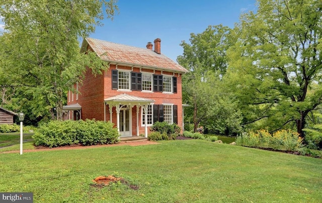 612 Old Rte 322, Spring Mills, PA 16875 - view of front of property featuring a chimney, a front lawn, brick siding, and metal roof
