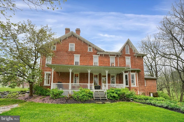 612 Old Rte 322, Spring Mills, PA 16875 - view of front of house with a chimney, brick siding, covered porch, and a front yard