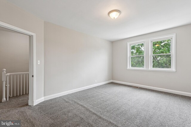 carpeted empty room with baseboards