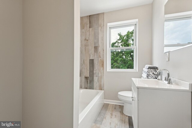 full bathroom featuring vanity, toilet, a shower, wood finished floors, and a tub