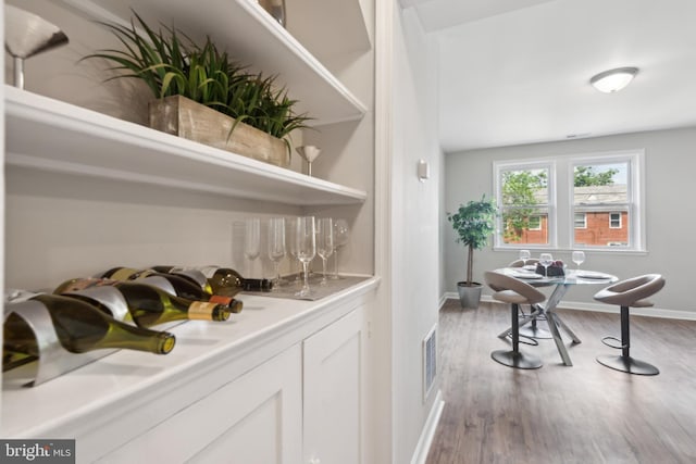 bar featuring wood finished floors and baseboards