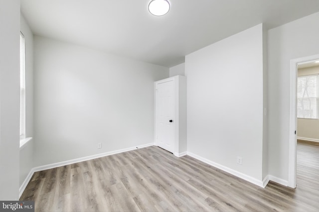 spare room with wood finished floors and baseboards