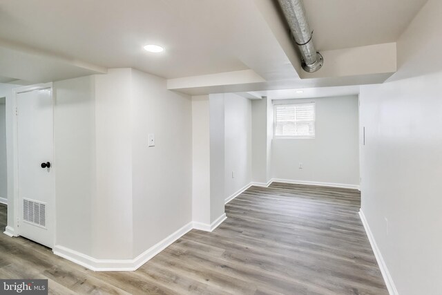 basement with baseboards, wood finished floors, and recessed lighting