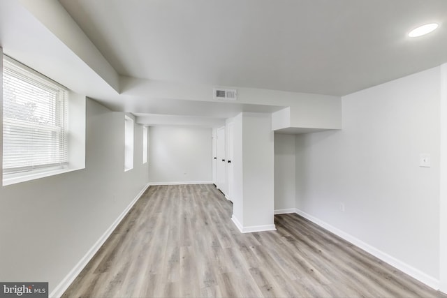 below grade area with light wood-style floors and baseboards