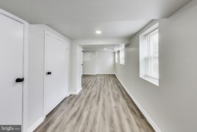 basement featuring light wood finished floors, baseboards, and recessed lighting