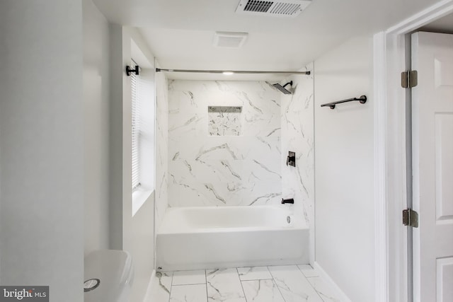 bathroom with marble finish floors, shower / bath combination, and toilet