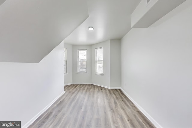 additional living space featuring wood finished floors and baseboards