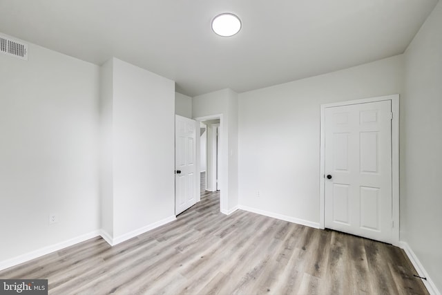unfurnished bedroom with wood finished floors and baseboards