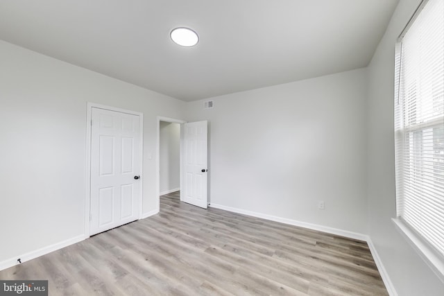 unfurnished bedroom with wood finished floors and baseboards