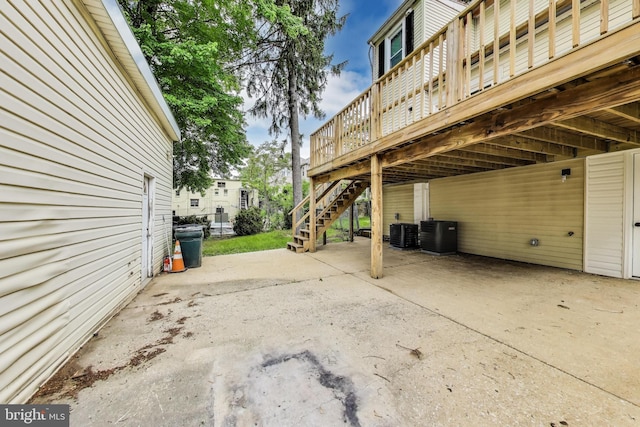 view of patio / terrace with stairs, a wooden deck, and central AC