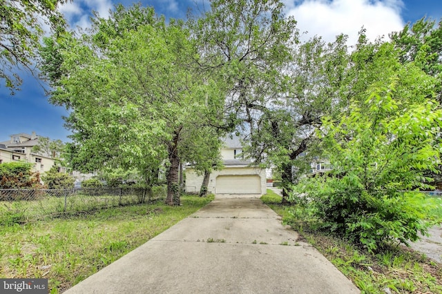 view of front of house with fence, a garage, and concrete driveway