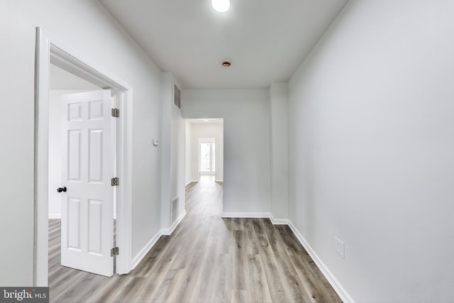 hall featuring wood finished floors and baseboards