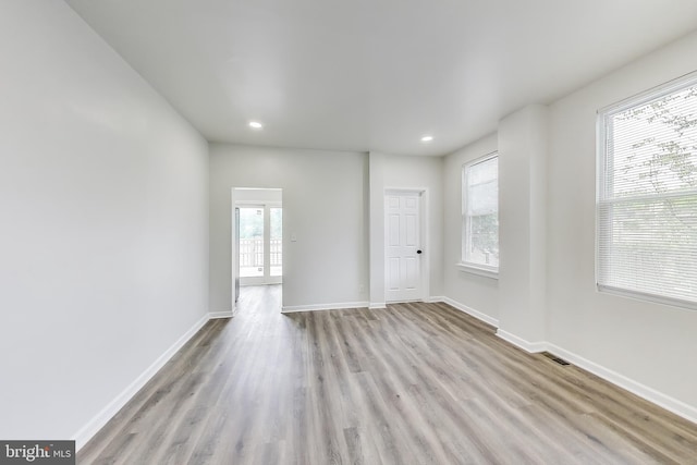 unfurnished room featuring wood finished floors, recessed lighting, and baseboards