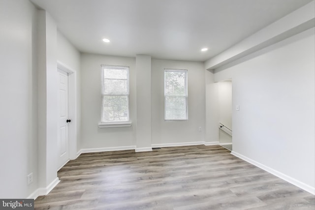 spare room with wood finished floors, recessed lighting, and baseboards
