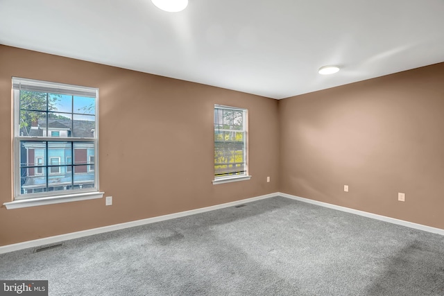 carpeted spare room featuring baseboards