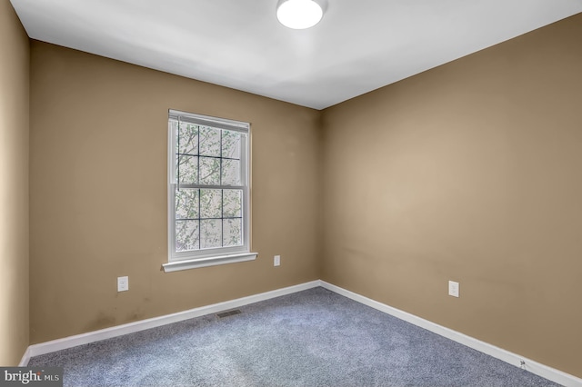 carpeted spare room featuring baseboards