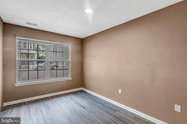 unfurnished room featuring baseboards, wood finished floors, and recessed lighting