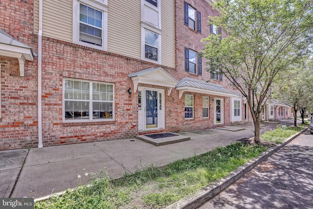 doorway to property featuring brick siding