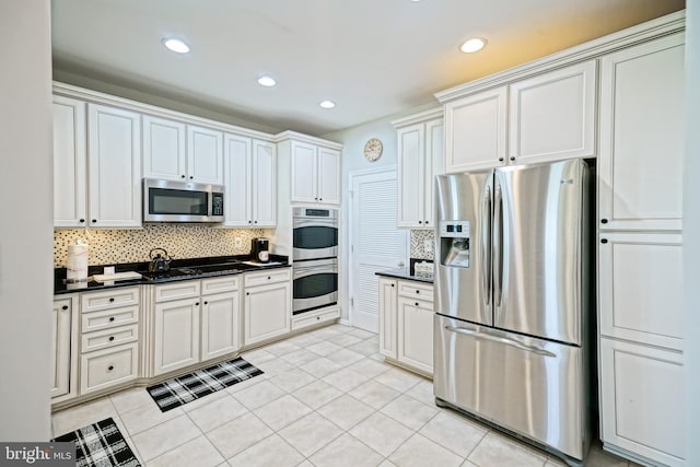 24928 Rivers Edge Rd, Millsboro, DE 19966 - kitchen with stainless steel appliances, dark countertops, backsplash, recessed lighting, and light tile patterned floors