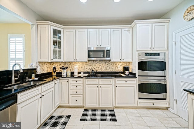 24928 Rivers Edge Rd, Millsboro, DE 19966 - kitchen with appliances with stainless steel finishes, backsplash, light tile patterned floors, glass insert cabinets, and recessed lighting