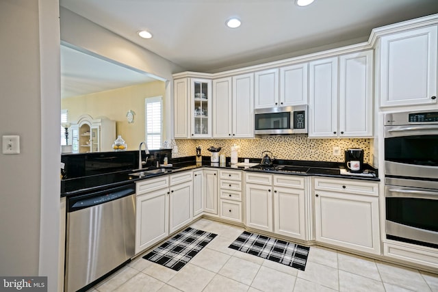 24928 Rivers Edge Rd, Millsboro, DE 19966 - kitchen with stainless steel appliances, tasteful backsplash, glass insert cabinets, light tile patterned floors, and recessed lighting