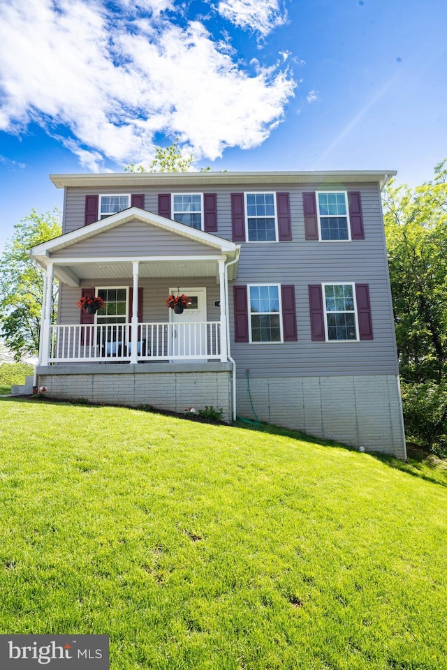 view of front facade featuring a front yard and covered porch