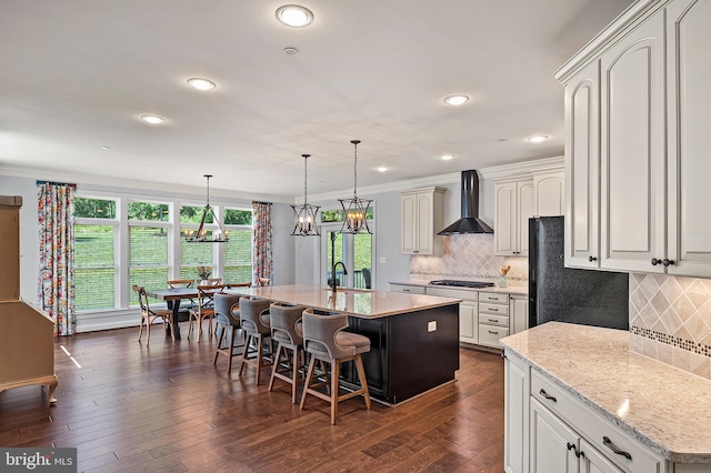 1760 Florence Rd, Mount Airy, MD 21771 - kitchen with wall chimney range hood, stainless steel gas stovetop, a center island with sink, a sink, and a breakfast bar