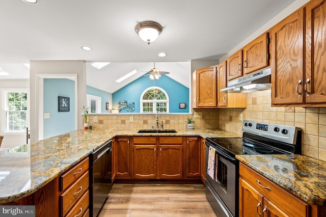 kitchen with electric range, a sink, under cabinet range hood, dishwashing machine, and plenty of natural light