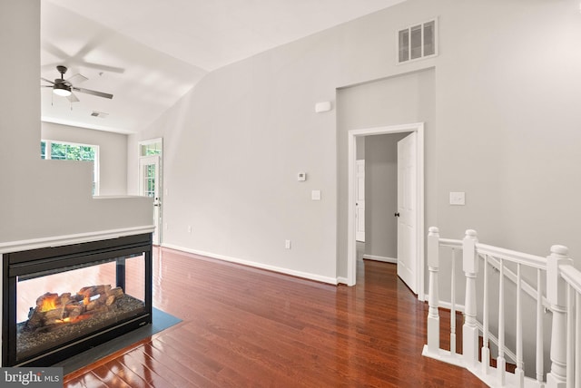 living area featuring a ceiling fan, wood finished floors, lofted ceiling, and baseboards
