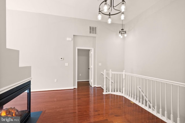unfurnished dining area featuring wood finished floors, a chandelier, and baseboards