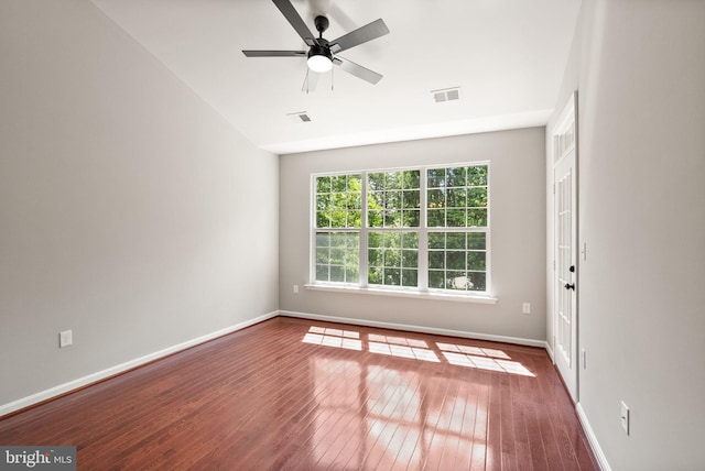 empty room with hardwood / wood-style floors, baseboards, a ceiling fan, and lofted ceiling