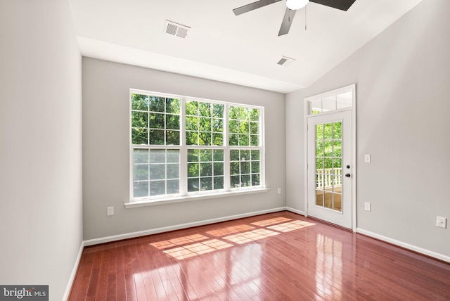 empty room with hardwood / wood-style floors, a ceiling fan, baseboards, and lofted ceiling