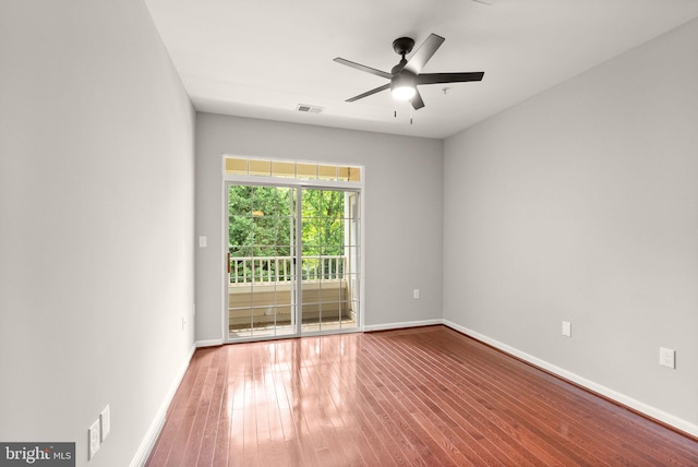 spare room featuring wood finished floors, ceiling fan, and baseboards