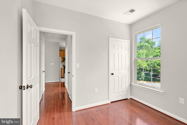 unfurnished bedroom with wood finished floors and baseboards