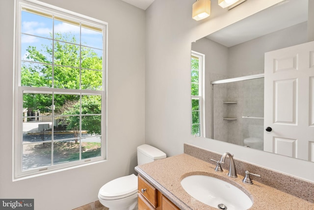 bathroom with toilet, a tile shower, and vanity