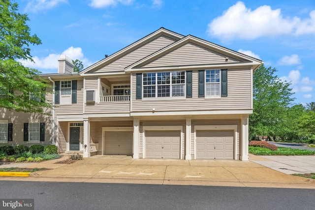 view of front of property featuring an attached garage, concrete driveway, a chimney, and a balcony