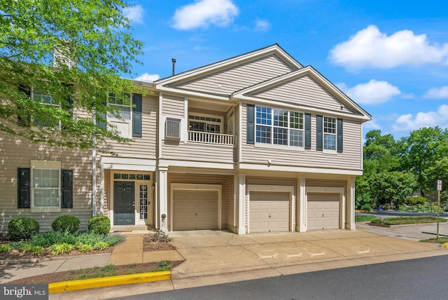 view of property featuring a garage, a balcony, and concrete driveway