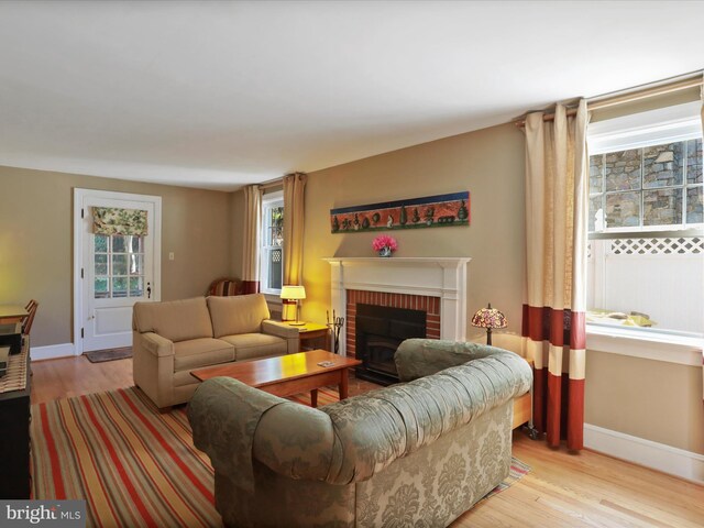 210 W 1st St, Front Royal, VA 22630 - living area featuring wood finished floors, a brick fireplace, and baseboards
