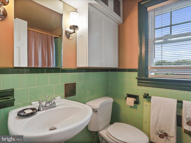 210 W 1st St, Front Royal, VA 22630 - bathroom featuring a sink, toilet, tile walls, a shower with curtain, and wainscoting