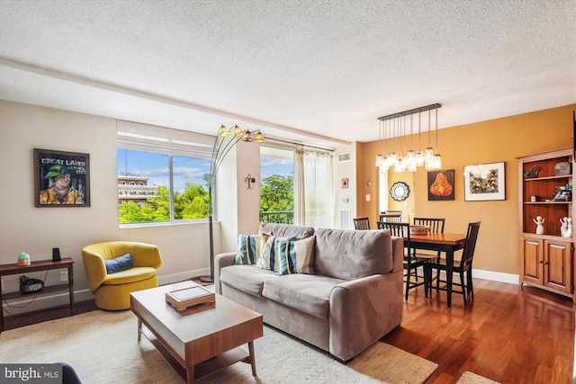 living room featuring wood finished floors, baseboards, and a textured ceiling