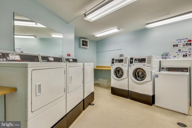 communal laundry room with independent washer and dryer