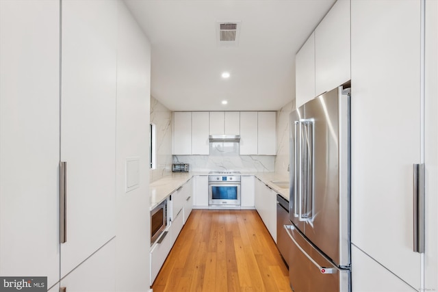 kitchen featuring appliances with stainless steel finishes, white cabinetry, modern cabinets, and recessed lighting