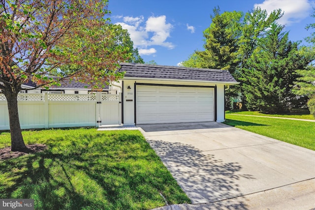 garage with concrete driveway and a gate