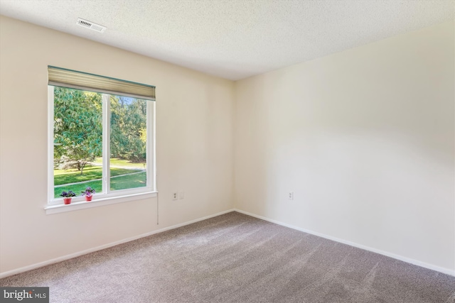 spare room featuring carpet flooring, a textured ceiling, and baseboards